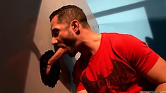 Big guy in red t-shirt finds cute dick popping up from glory hole and sucks it